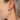 Side view of model wearing the Summer Loving Earrings in Tortoise which features open, small hoops with dark brown and tan tortoise design.