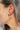 Side view of model wearing the Summer Loving Earrings in Tortoise which features open, small hoops with dark brown and tan tortoise design.