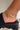 Side view of model wearing the Double The Trouble Anklet which features two gold layers, one layer with gold flat design and the other layer is a gold roping design.