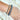 Close up view of model wearing the Half and Half Bracelet in Black which features three stack of stretchy bracelets with small gold beads, small black beads and large black beads.