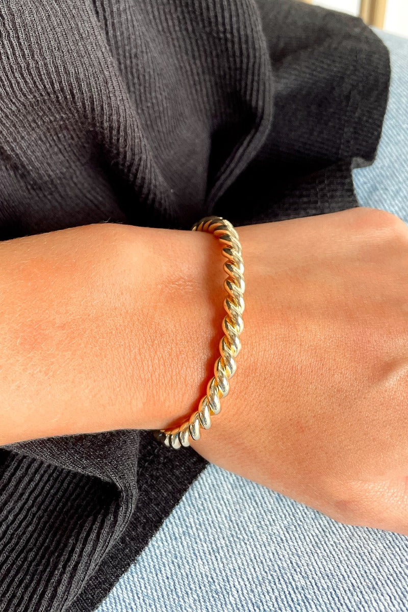Close up view of model wearing the Classic Rope Bracelet which features gold adjustable bangle with roping design.