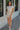 Full body front view of model wearing the Going Coastal Shorts in Oatmeal that feature oatmeal fabric, pockets on each side, an elastic waistband and a folded hem