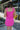 Back view of model wearing the Sweet Summertime Dress that features hot pink fabric, a v-neckline, and tie straps