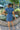 Full back view of model wearing the East Side Denim Dress that has dark wash denim fabric, mini length, pockets, a silver button up front, a collared neck, a tie around the waist, and short sleeves.