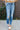 Front view of model wearing the Rooted Denim: Uniquely Me Jeans which features dark denim wash fabric, straight legs, two front pockets, two back pockets, distressed details, a front zipper with a button closure and belt loops.