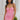 Front view of model wearing the I'm Smitten Dress in Pink that has pink ruched mesh fabric, pink lining, a strapless wire v-neck, and a back zipper and hook closure