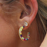 Close up of model wearing the Keep It Colorful Earrings that feature small gold open hoops with blue, turquoise, red, pink, light green and yellow beads.