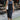 Front view of model wearing the Bristol Ruched Midi Dress in Black that has black knit fabric, midi length, ruched side details, a side slit, a round neckline and a sleeveless design