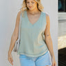 Front view of model wearing the Bon Voyage Tank Top in Sage that has sage gauze fabric, green stitching, small slits on each side, a v-neckline and a sleeveless design