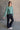 Full body side view of model wearing the Nicole Green Cropped Long Sleeve Sweatshirt that has gray-green cotton fabric, a cropped waist, a round neckline and long sleeves.