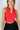 Front view of model wearing the Jada Red Cropped Racerback Tank Top that has red knit fabric, a cropped waist, built-in padding, a v-neckline with a collar, and a sleeveless design.