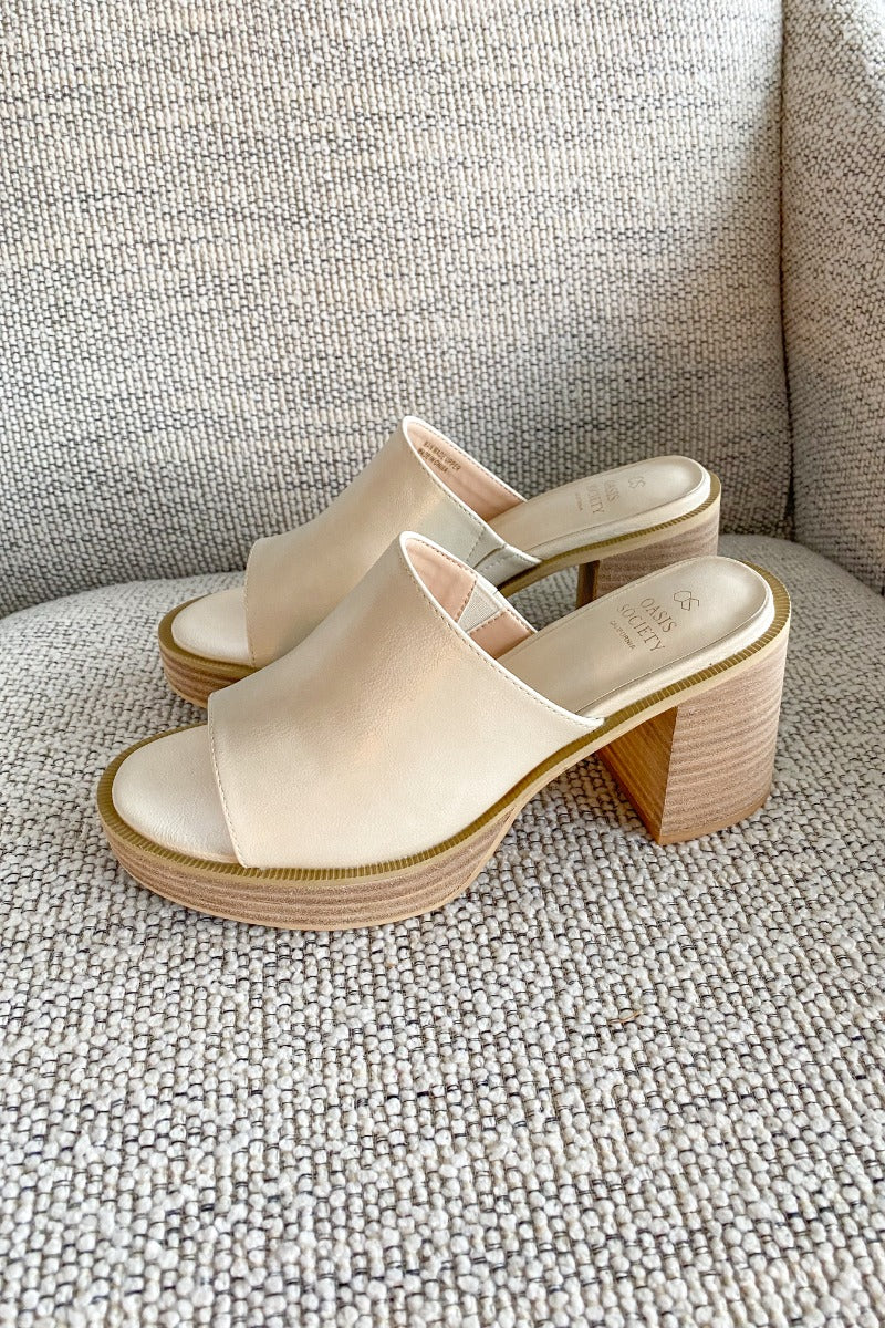 Side view of the Camille Platform Mules that feature a beige faux-leather upper, slide entry, a 1" platform, and a 3.5" block heel