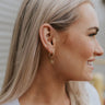 Side view of model wearing the Fan Of You Earrings which features gold mini closed hoops with a fan shaped attachment.