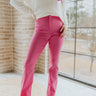 Front view of model wearing the Think Pink Pants that have pink fabric, a front zipper and hook closure, and flared legs
