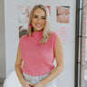 Front view of model wearing the Let's Stay Together Top which features pink knit fabric, a high mock neckline, a sleeveless body and a ribbed hem.
