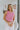 Front view of model wearing the Crushing On You Top which features pink bubble fabric, a cropped waist, a round neckline, a back keyhole with button a closure, and a sleeveless body.