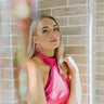 Front view of model wearing the Some Of That Earrings in Pink which features gold circle linked to a gold square dipped in blue and pink.