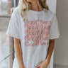 Close up view of model wearing the Good Times Top which features white cotton fabric, a round neckline, and short sleeves. The graphic says "Good Times" five times with a pink heart background.