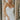 Front view of model wearing the Wishful Thinking Dress which features white fabric, mini length, overlap neckline with extra fabric, back sheer fabric with bands and gold zipper.