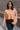 Front view of model wearing the Nina Peach Cropped Long Sleeve Sweater which features peach knit fabric, a ribbed round neckline, dropped shoulders with exposed seams, and long flare sleeves.