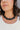 Close up of model wearing the Kendall Black Chain Link Statement Necklace that has square shaped links with a black and white marble design and a gold adjustable link closure.
