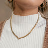 Front view of model wearing the Ella Gold Pointed Herringbone Necklace that has one gold flat herringbone link, a pointed design with clear stones, and an adjustable clasp closure