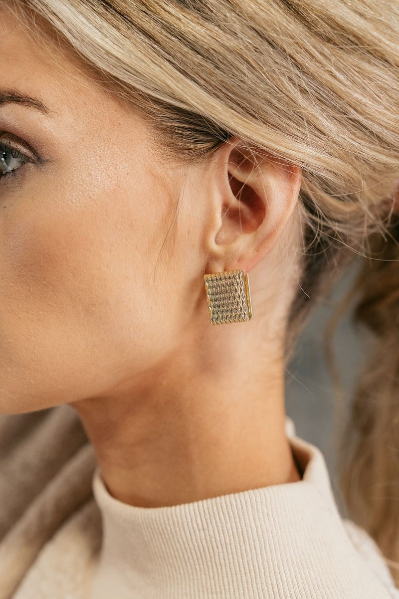 Side view of model wearing the Victoria Gold Rectangle Earrings that feature gold rectangles with dimensional shape designs.
