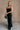 Full body front view of model wearing theElisa Black Satin Cowl Neck Maxi Dress that havs black satin fabric, maxi length,, a cowl neck, adjustable straps, and a back zipper with a hook closure.