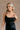 Upper front view of model wearing theElisa Black Satin Cowl Neck Maxi Dress that havs black satin fabric, maxi length,, a cowl neck, adjustable straps, and a back zipper with a hook closure.