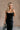 Upper front view of model wearing theElisa Black Satin Cowl Neck Maxi Dress that havs black satin fabric, maxi length,, a cowl neck, adjustable straps, and a back zipper with a hook closure.