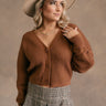 front view of model wearing the Lana Brown Ribbed Cropped Cardigan that has brown ribbed knit fabric, monochrome buttons, a plunge neckline, and long balloon sleeves with cuffs.