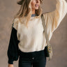 Front view of model wearing the Stella Cream Multi Long Sleeve Sweater which features cream, black and grey knit fabric, color block pattern, ribbed hem, round neckline, dropped shoulders and long balloon sleeves with cuffs.