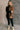 Full body view of model wearing the Freya Brown & Black Color Block Long Sleeve Sweater which features black and brown knit fabric, color-block pattern, high neckline, dropped shoulders and long sleeves with cuffs.