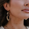 Side view of model wearing the Kaia Gold Teardrop Earrings that feature two gold ribbed teardrop shaped hoops linked together.
