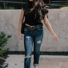 Full body front view of model wearing the Rooted Denim: Kali Dark Wash Distressed Jeans that have dark wash denim, distressing, a front zipper and two-button closure, pockets, belt loops, and straight legs
