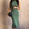 Full body view of model wearing the Mariana Green Sleeveless Mock Neck Midi Dress which features forest green knit fabric, high neckline, midi length, slit in the back and sleeveless.