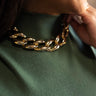 Close up view of model wearing the Stella Gold Thick Chain Necklace which features shiny, large gold chain links with an adjustable clasp closure.