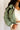 Close front view of model wearing the Mckinley Mint Cropped Puffer Jacket that has mint green puffer fabric, a cropped waist, a front zipper with snaps, a hood, and long sleeves.