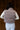 Back view of model wearing the Aliana Grey Corduroy & Sherpa Puffer Vest that has grey corduroy fabric, a drawstring hem, sherpa lining, a monochrome zipper, and a high neckline.