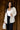 front view of model wearing the Elena Beige Open Front Cardigan that has beige knit fabric, two front pockets, ribbed trim , an open front, and long sleeves.