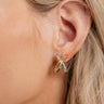 Side view of model weaaring the Melody Gold & Silver Cross Hoop which features open gold and silver cross hoops.