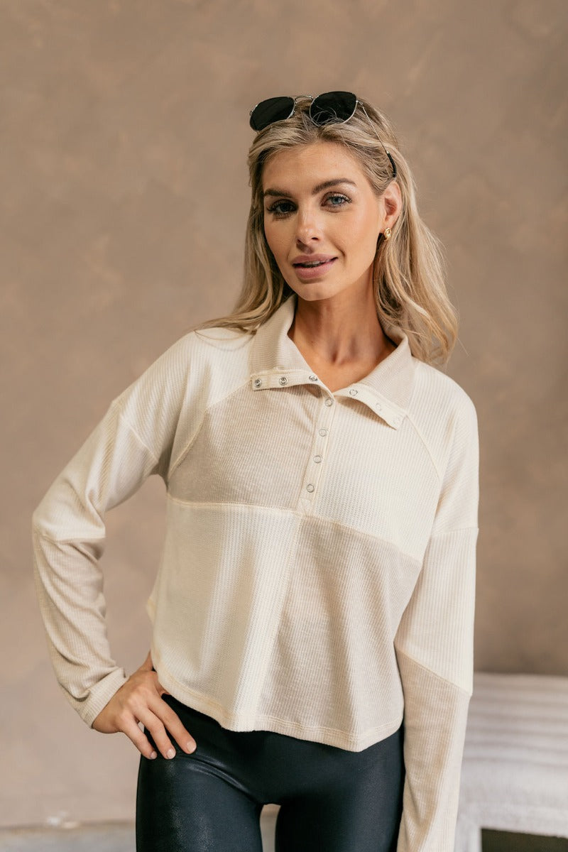 Front view of model wearing The Julia Cream Color Block Thermal Top features cream and taupe waffle knit fabric, color block pattern, quarter button up closure, high neckline, dropped shoulders and long sleeves.