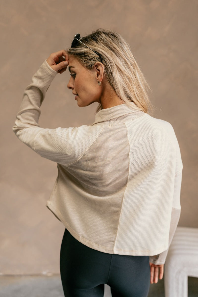 Back view of model wearing The Julia Cream Color Block Thermal Top features cream and taupe waffle knit fabric, color block pattern, quarter button up closure, high neckline, dropped shoulders and long sleeves.