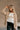 Front view of model wearing the Rebecca Taupe Patterend Shacket features taupe and white knit fabric, houndstooth print, two front slit pockets, taupe button up closure, two front buttoned chest pockets, collared neckline and long sleeves with buttoned cu