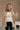 Front view of model wearing the Rebecca Taupe Patterend Shacket features taupe and white knit fabric, houndstooth print, two front slit pockets, taupe button up closure, two front buttoned chest pockets, collared neckline and long sleeves with buttoned cu