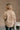 Back view of model wearing the Rebecca Taupe Patterend Shacket features taupe and white knit fabric, houndstooth print, two front slit pockets, taupe button up closure, two front buttoned chest pockets, collared neckline and long sleeves with buttoned cuf