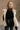 Front view of The Courtney Cream Sherpa Vest features beige textured fabric, two front slit pockets, side ties, monochrome button up closure, high neckline and sleeveless.