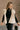 Front view of The Courtney Cream Sherpa Vest features beige textured fabric, two front slit pockets, side ties, monochrome button up closure, high neckline and sleeveless.