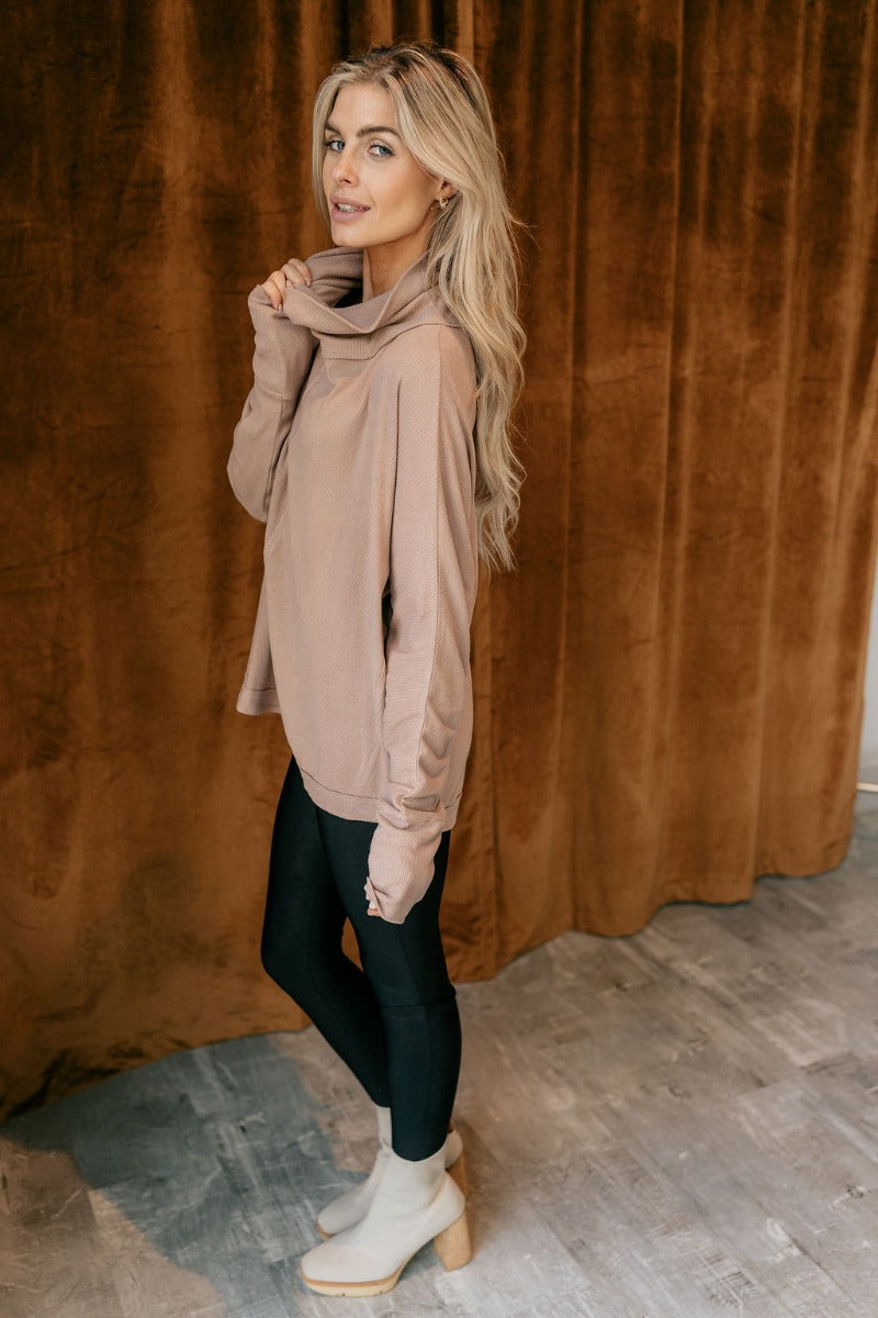 Side view of model wearing The Luca Mocha Turtleneck Top features mocha knit fabric, high neckline, textured details and long sleeves.