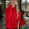 Front view of model wearing The Claire Red Ribbed Turtleneck Sweater features red cable knit fabric, turtleneck neckline, dropped shoulders and long wide sleeves.